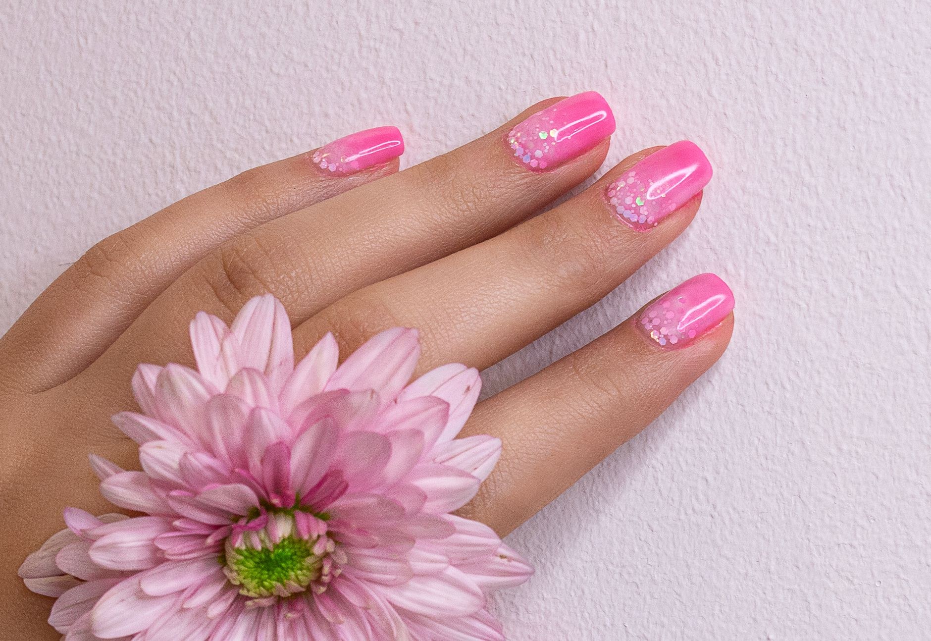 Soft pink glitter manicure with a flower